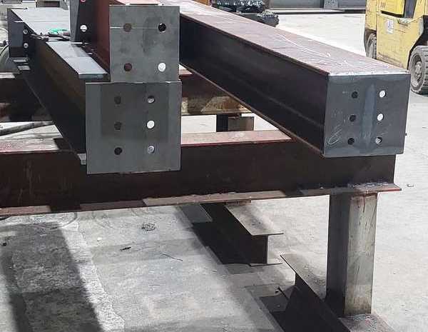 Beams with welded, drilled end plates