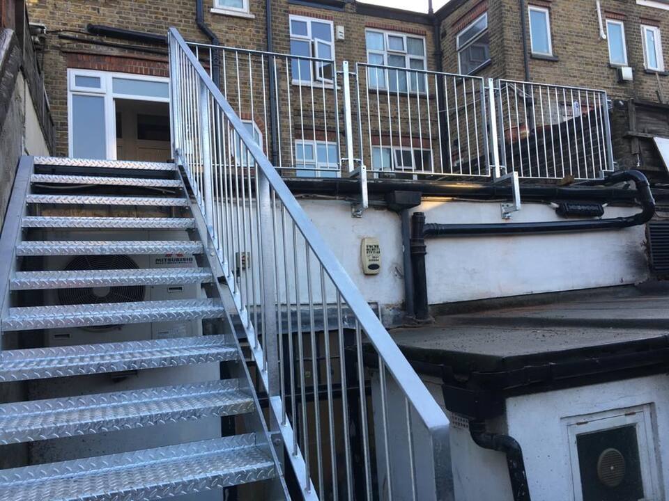 Galvanised stair up to a rear roof terrace
